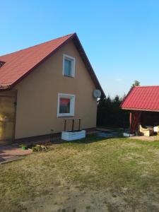 dom z czerwonym dachem i dziedzińcem w obiekcie Dom wakacyjny u Alicji w Pasymiu