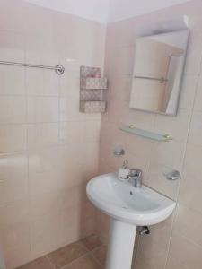 a white bathroom with a sink and a shower at Papas Apartments in Moírai