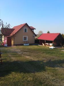 dom z czerwonym dachem i dziedzińcem w obiekcie Dom wakacyjny u Alicji w Pasymiu