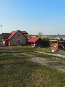 dom z czerwonym dachem i dziedzińcem w obiekcie Dom wakacyjny u Alicji w Pasymiu