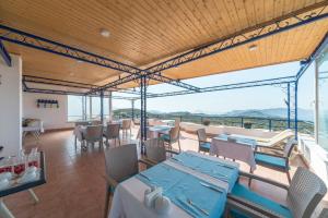 a restaurant with tables and chairs and a view of the ocean at Miramar Pansiyon in Kaş