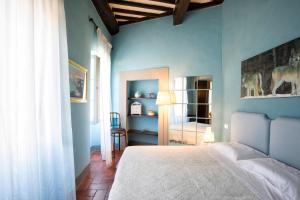 a bedroom with a bed and a blue wall at Casa del Loggiato in Cortona