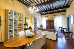 a dining room with a wooden table and white chairs at Casa del Loggiato in Cortona