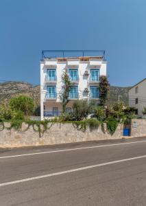 a white building on the side of a road at Miramar Pansiyon in Kaş