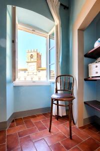 a chair sitting in a room with a window at Casa del Loggiato in Cortona
