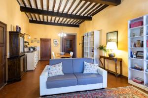 a living room with a blue couch and a table at Casa del Loggiato in Cortona