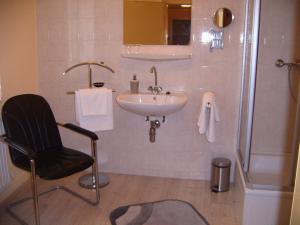 La salle de bains est pourvue d'un lavabo, d'une chaise et d'une douche. dans l'établissement Haus Sonnenschein, à Hahnenklee