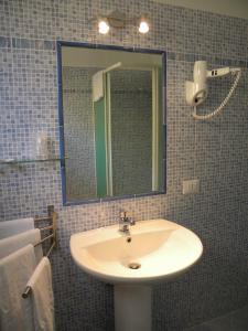 La salle de bains est pourvue d'un lavabo et d'un miroir. dans l'établissement Grand Hotel Dei Cesari Dependance, à Anzio