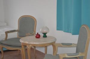 a table and two chairs and a table with a lamp on it at Miramar Pansiyon in Kaş