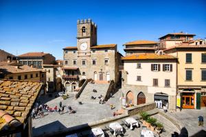 una città con una torre dell'orologio e un gruppo di persone di Casa del Loggiato a Cortona