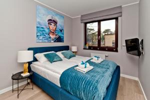 ユラタにあるVilla Aqua BlueApart Jurataのベッドルーム(青いベッド1台、窓付)