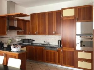 a kitchen with wooden cabinets and stainless steel appliances at Veneto Civico 17 in Sarnico