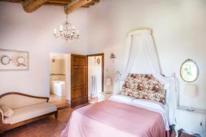 Schlafzimmer mit einem Bett und einem Kronleuchter in der Unterkunft Agriturismo Pieve Sprenna in Buonconvento