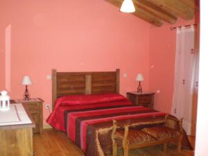 1 dormitorio con 1 cama grande con manta roja en Casa Rural Los Molinillos, en Caballar