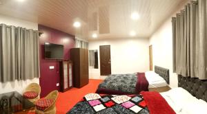 Cette chambre comprend un lit et une télévision. dans l'établissement FRATERNITY HOMESTAY, à Darjeeling