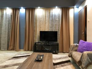 ein Wohnzimmer mit einem Sofa und einem Flachbild-TV in der Unterkunft Iridas house in Kos-Stadt