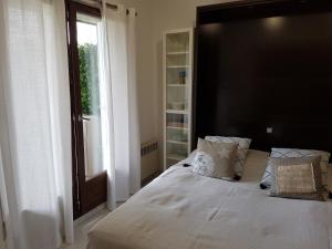 um quarto com uma cama grande e uma cabeceira preta em Appartement 2 pièces rez-de-jardin à 2 pas de la plage et de la thalasso em Cabourg