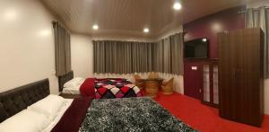 Un dormitorio con dos camas y un televisor de pantalla plana. en FRATERNITY HOMESTAY, en Darjeeling