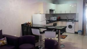 a kitchen with a table and chairs and a refrigerator at Appartement Agadir Awrir in Agadir