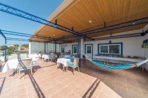 a patio with a hammock and tables and chairs at Miramar Pansiyon in Kaş