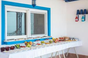 a table with plates of food on it with two windows at Miramar Pansiyon in Kaş