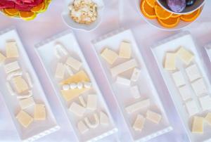 a table topped with plastic containers of cheese and fruit at Miramar Pansiyon in Kaş