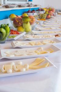 a row of white plates filled with cheese and fruit at Miramar Pansiyon in Kaş