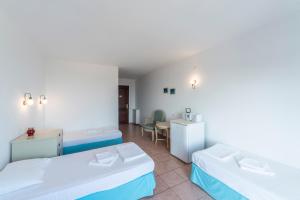 a hotel room with two beds and a table at Miramar Pansiyon in Kaş