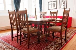 a wooden dining room table and chairs on a rug at Apartment Zentral in Tübingen