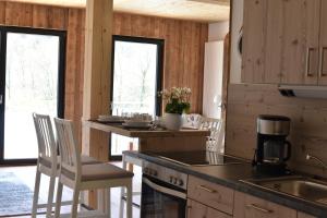 a kitchen with wooden cabinets and a table and chairs at Heinfling Chalet Essing in Essing