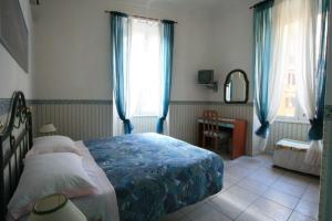 a bedroom with a bed and a desk and windows at Alex B&B in Rome