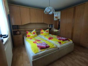sypialnia z dużym łóżkiem z żółtymi i czerwonymi poduszkami w obiekcie Ferienwohnung Erholung am Hainich w mieście Bischofroda