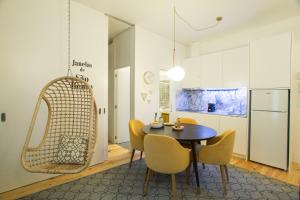 a kitchen and dining room with a table and chairs at Janelas de São Bento by Porto City Hosts in Porto