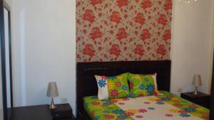 a bedroom with a bed with colorful pillows at Appartement standing Nabeul in Nabeul