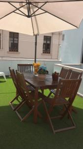 a wooden table with chairs and an umbrella at Casa Azul Hostel in Sintra