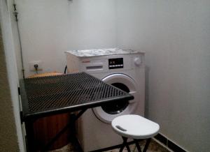 una piccola camera con lavatrice e sgabello di A cozy flat in the heart of El Fraile a Las Galletas