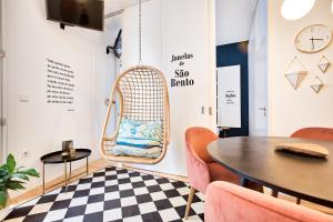 una habitación con una silla de mimbre y una mesa en Janelas de São Bento by Porto City Hosts, en Oporto