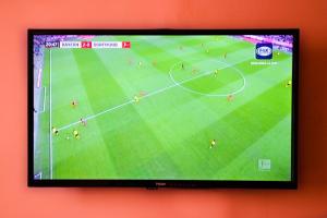 una televisione appesa a un muro con una partita di calcio di Hotel Margarita a Puno