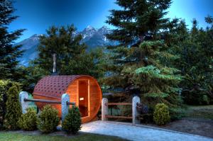a hobbit house in a forest with mountains in the background at La Roche Hotel Appartments in Aosta
