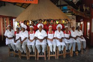 un grupo de chefs posando para una foto bajo un paraguas en Oppi-Koppi Rest Camp, en Kamanjab