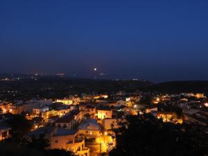 een stad verlicht in de nacht met lichten bij Hill View Hotel Apartments in Pissouri