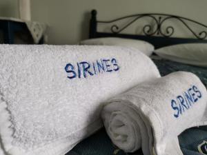 two towels on a bed with the words stanzas at Sirines in Vlachata