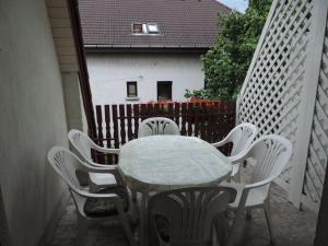 a table and chairs on a balcony with a fence at Füvesi Vendégház in Balatonfüred