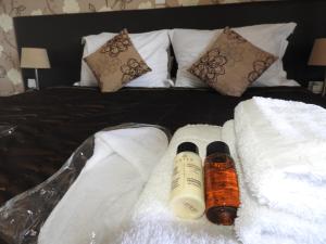 1 cama con toallas blancas y 2 botellas de protector solar en Hill View Hotel Apartments, en Pissouri