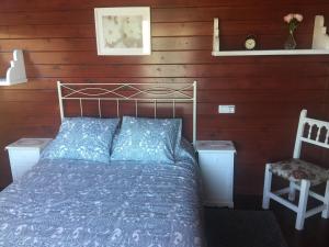 Un dormitorio con una cama y una pared de madera. en BellasVistas, en Beloncio