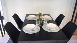 ヴァルムドエーにあるModern Villa in Stockholm Archipelagoの黒いテーブル(皿、メガネ、花付)