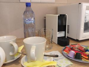 a table with two cups and a bottle of water at Hill View Hotel Apartments in Pissouri