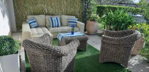 a patio with three wicker chairs and a couch at Il Profumo di Capri in Massa Lubrense