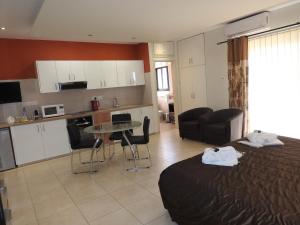 a bedroom with a bed and a kitchen with a table at Hill View Hotel Apartments in Pissouri