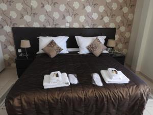 a bedroom with a bed with towels and shoes on it at Hill View Hotel Apartments in Pissouri
